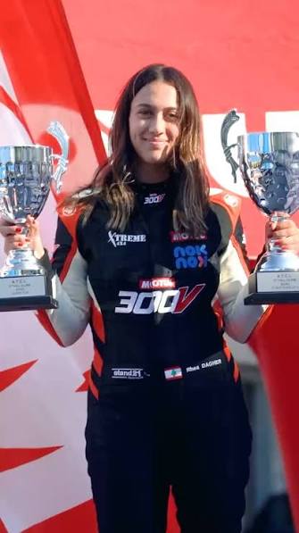 Rhea holding two motorsport trophies